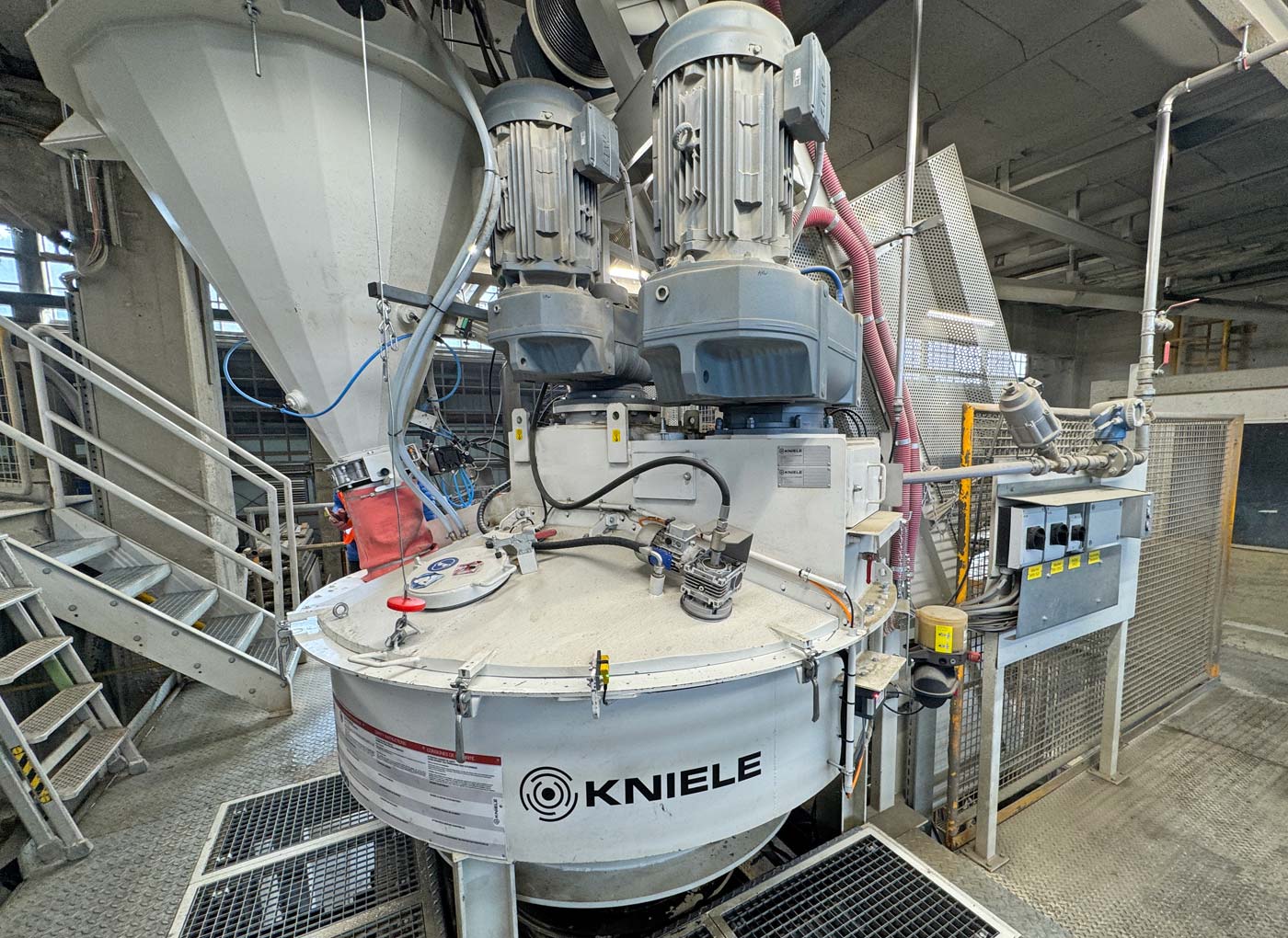 Mélangeur conique blanc Kniele avec balance à ciment à gauche et dosage d'eau à droite